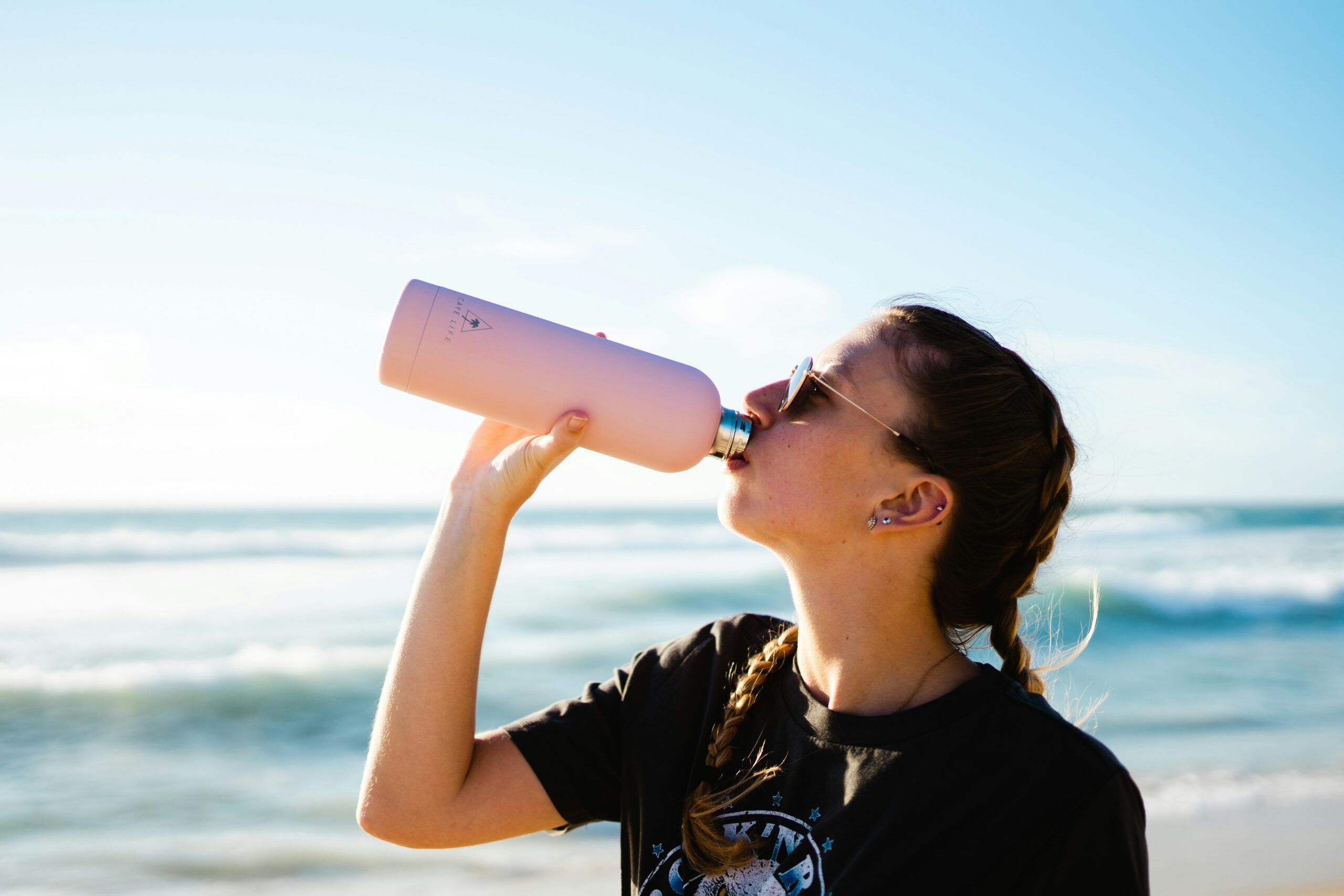 woman drinking water summer hydration products for summer workouts