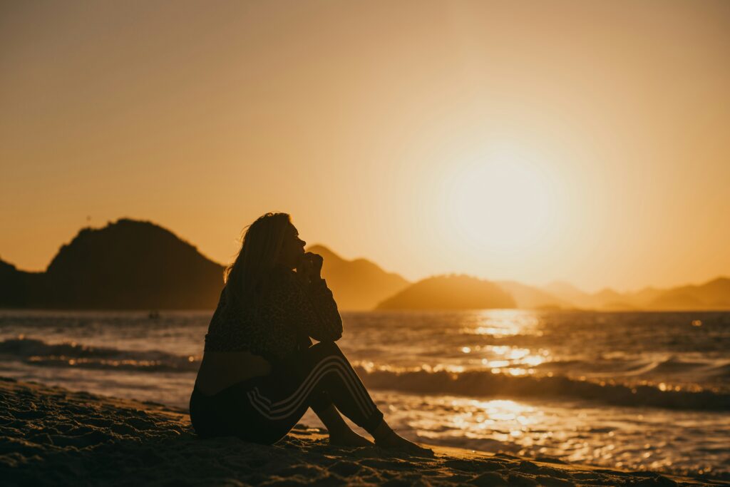 woman sitting in the sun beach summer depression symptoms