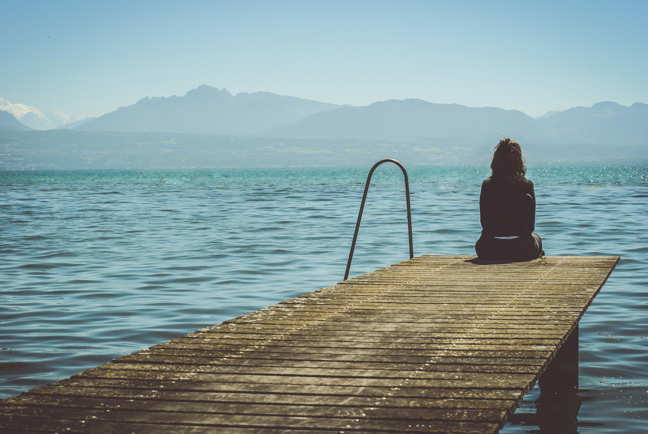 woman sitting on a dock sad summer depression symptoms