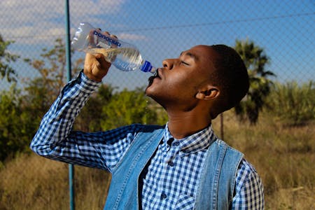 heat related illnesses man drinking water