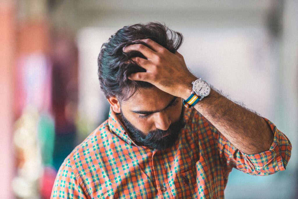 man touching his hair vitamins for hair growth