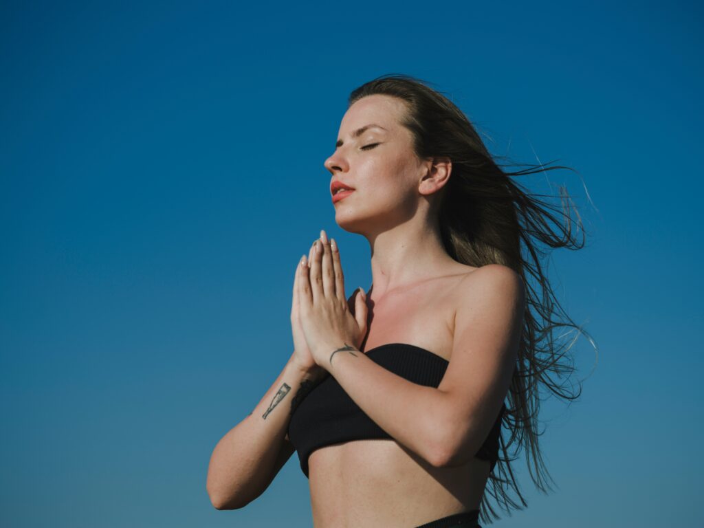 healthy woman meditating outside doing yoga peaceful signs your hormones are off