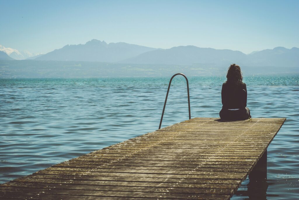 woman sitting on a dock sad summer depression symptoms