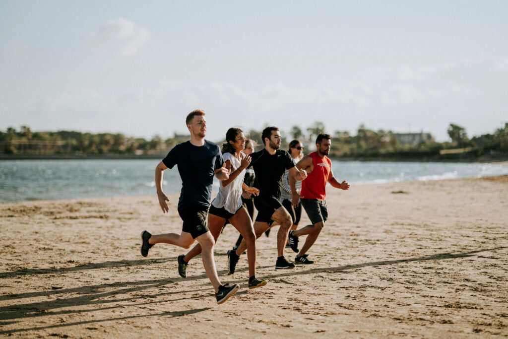 people running on the beach summer working out running shoes for calf pain