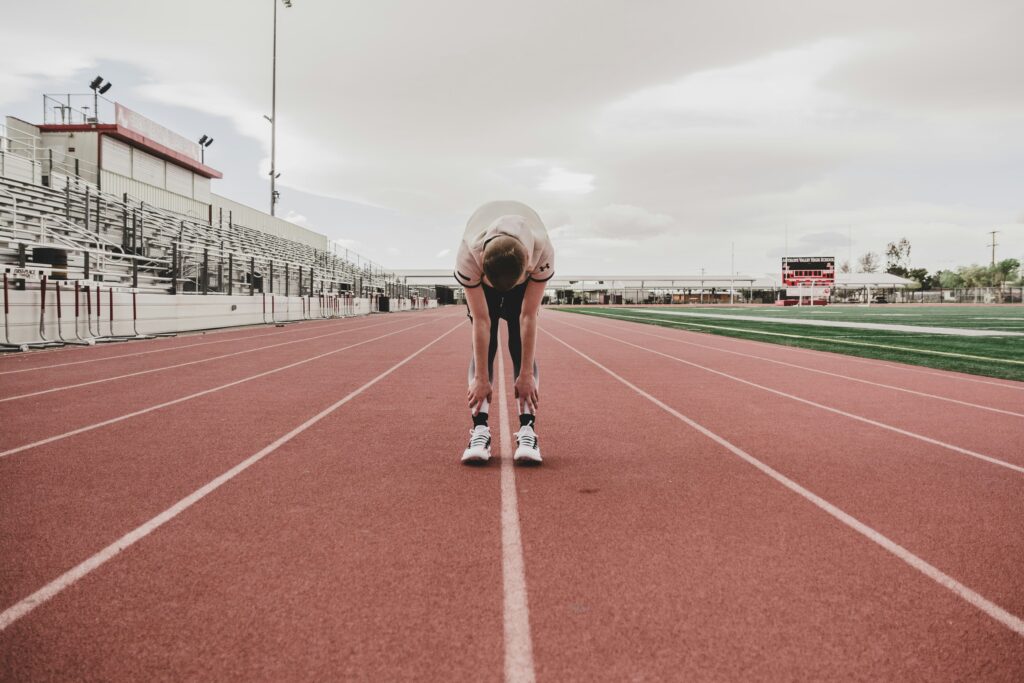 man stretching at a track after run running exercise fitness don't stretch after running