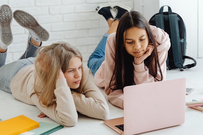 Mental health for teens - two girls looking at a pink laptop