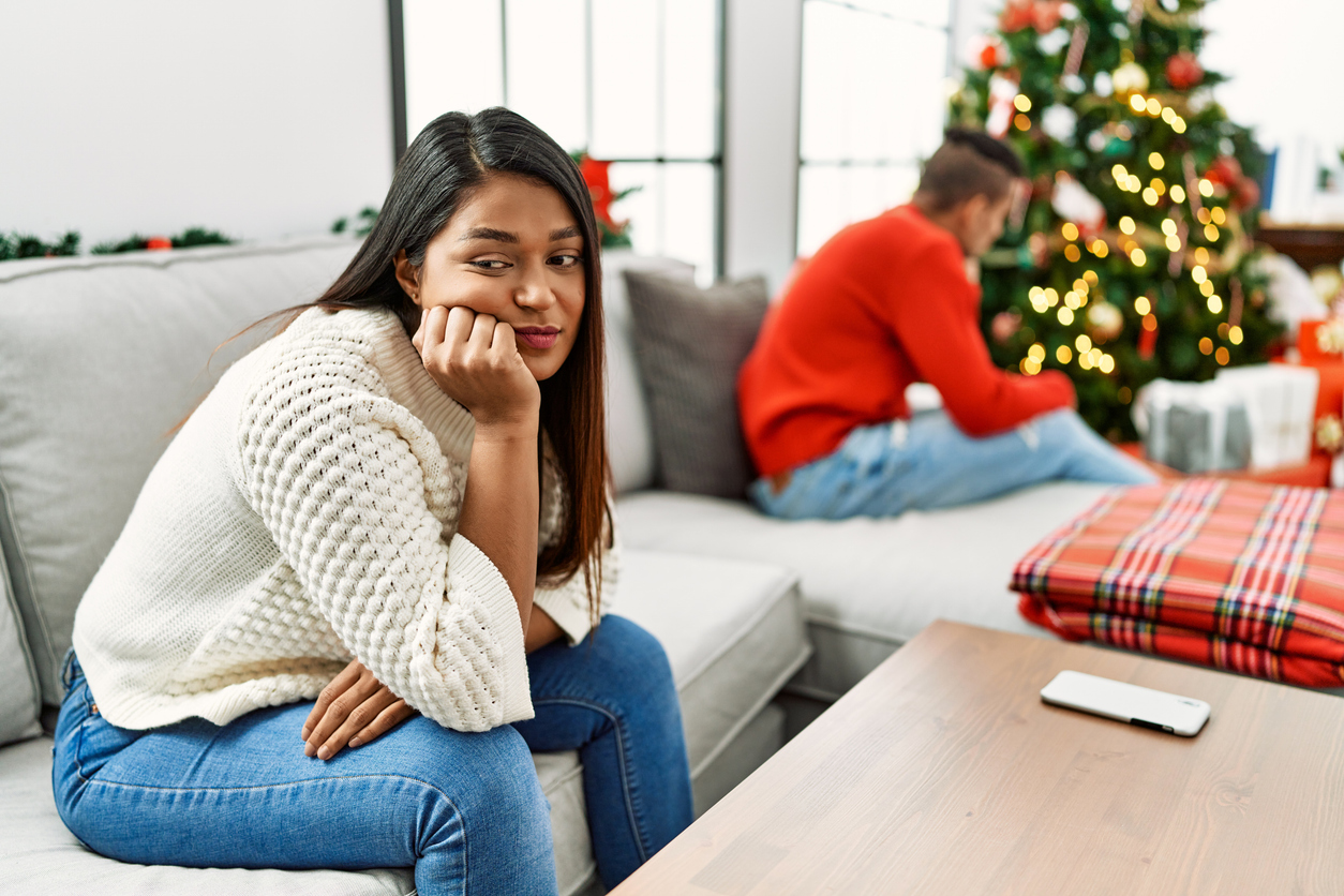 Young latin couple on problems with sad expression sitting on the sofa at home. holiday stress for couples