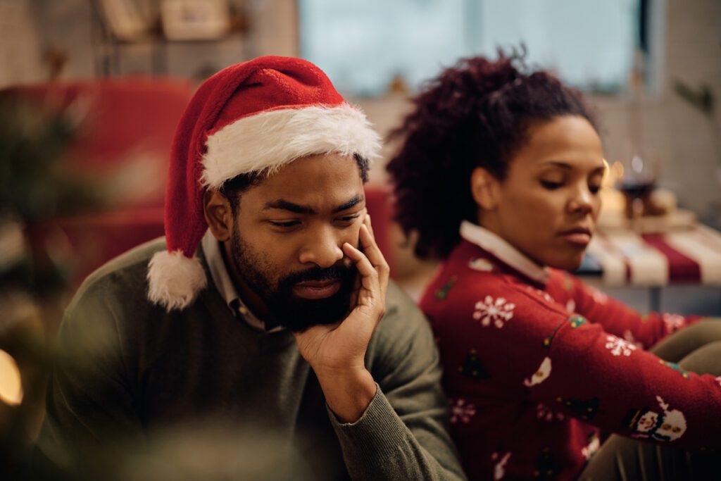 Distraught African American man arguing with his wife on Christmas. holiday stress for couples