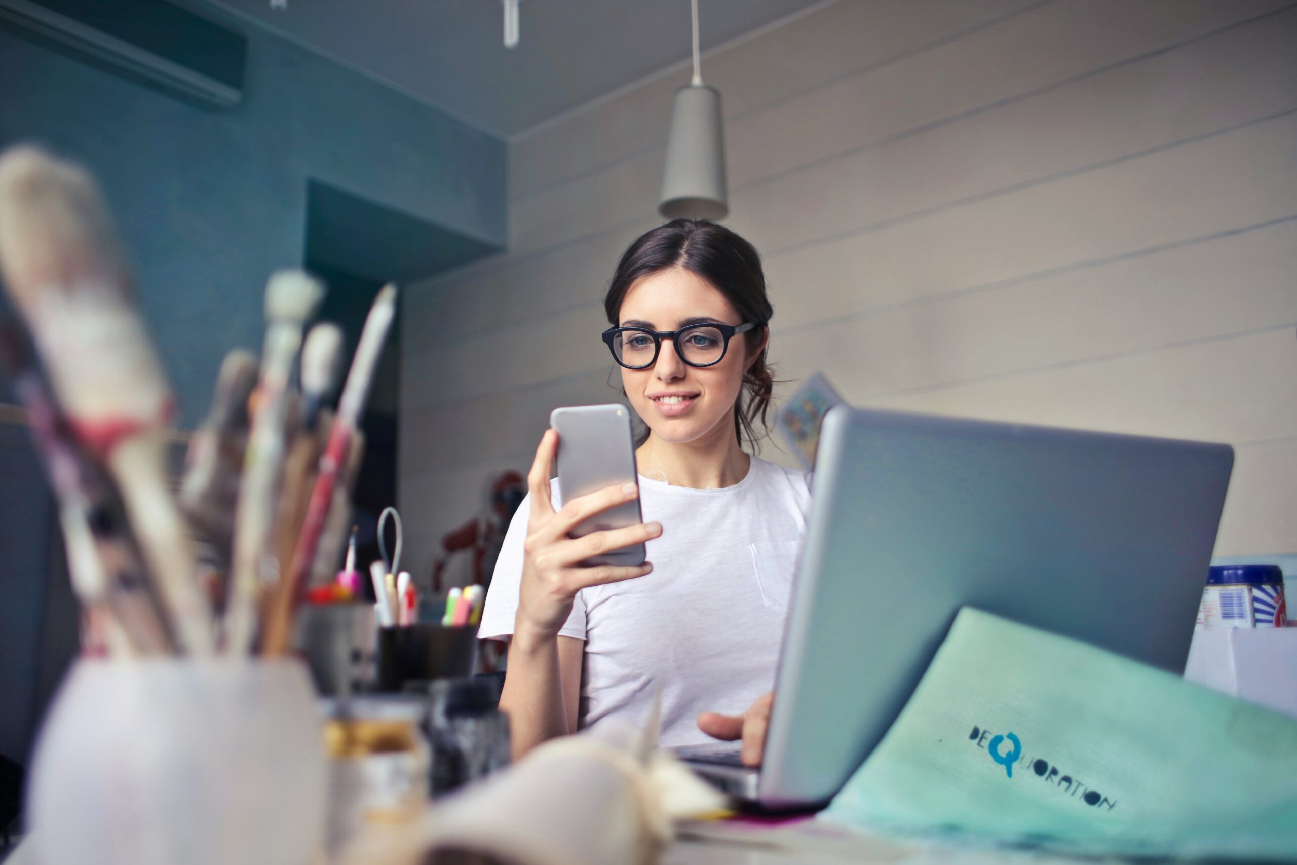 social media addiction - woman on phone at laptop