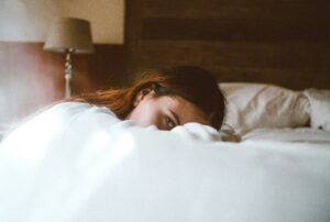 tired woman on bed - sleep anxiety