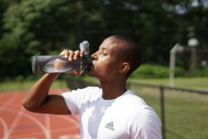 man drinking water at track - Intermittent Fasting During Hot Weather