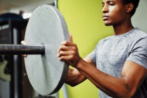 supplements for muscle - guy with weights at gym