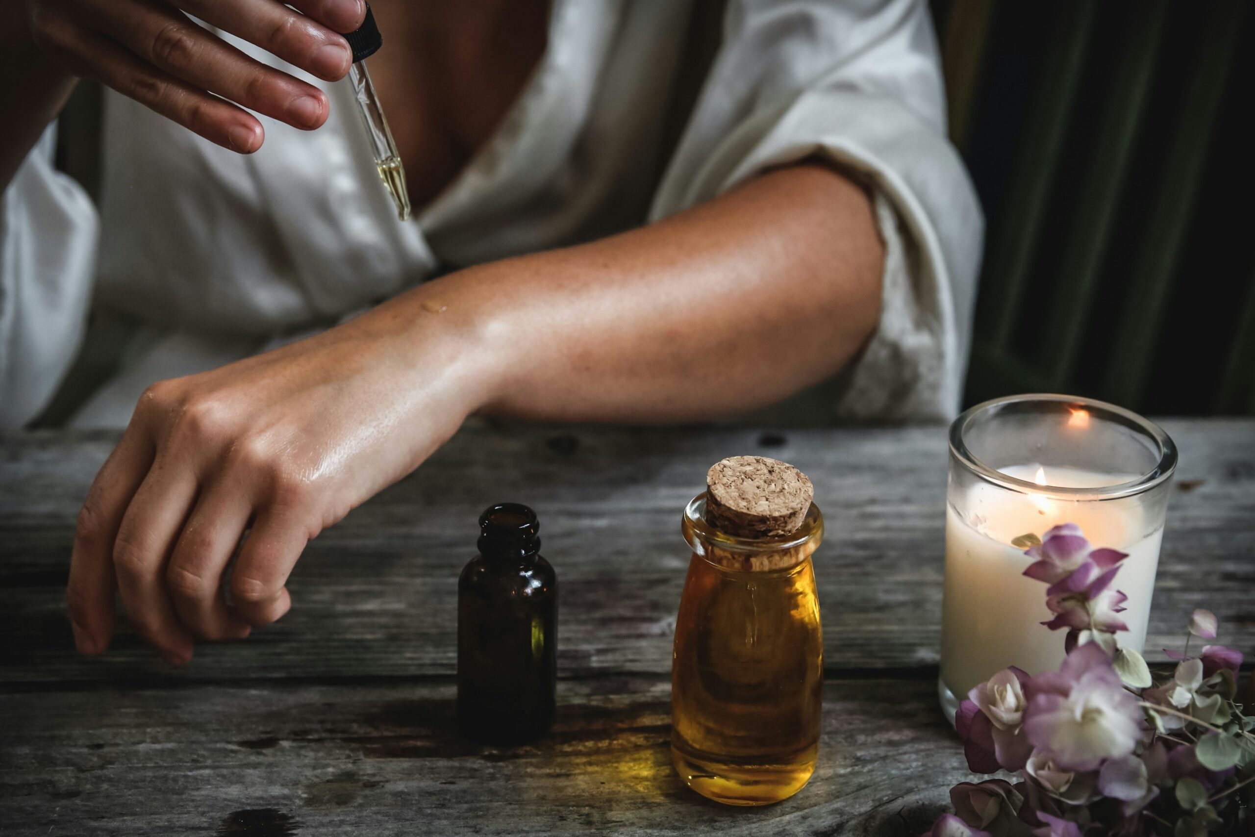 person putting on essential oils for aromatherapy massage