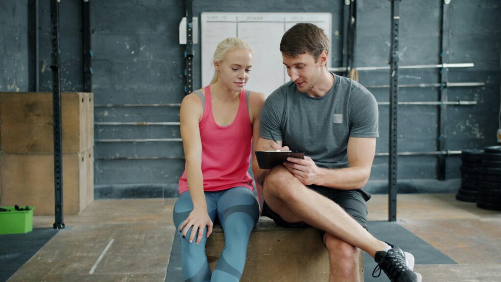 how to stick to fitness goals man and woman in the gym